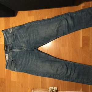 Blå jeans från Replay - Snygga blå jeans från Replay med klassisk femficksdesign och dragkedja. De har en modern passform och är perfekta för en avslappnad stil. Märkeslappen i läder baktill ger en extra touch av stil. Obs aldrig använda och det är mycket strech i dom. Priset kan diskuteras storlek 31/32