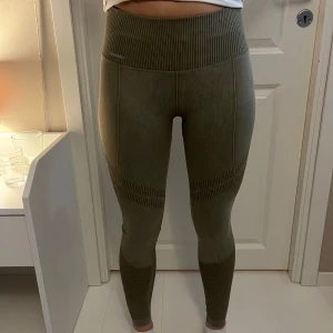 Gröna Amin träningstajts  - Snygga gröna leggings med ribbad midja och mönsterdetaljer längs benen. Helt nya, aldrig använda. Nypris 599. Modellen är 1,67 cm lång. Men jag är 172 o de passar mig lika bra 