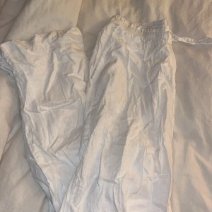 Vita linnebyxor med resårmidja - Säljer ett par vita linnebyxor med resårmidja och snörning. Perfekta för en avslappnad stil. Byxorna har en luftig passform och är tillverkade i ett lätt och bekvämt material.