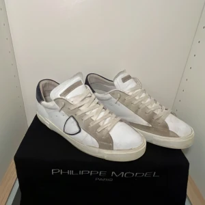 Philippe Model skor Storlek 41 - Hej, Jag säljer mina Philippe Model skor i vitt och beige med grå och blå detaljer. Skorna kommer med en Philippe Model skobox med en dust bag. Skorna passar även storlek 42. Skicket på skorna är 6/10.                             ÄKTA och ORIGINAL