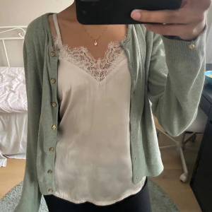 Jättefint sidenlinne från H&M - Jättefint linne från H&M i sidenmaterial med smala axelband och spetsdetaljer vid halsringningen. Köpt på Sellpy men säljer då den inte passa mig.💗