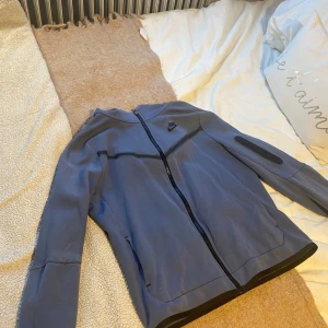 Blå Nike tech överdel  - Säljer denna Nike tech tröja som köptes för ungefär 2 år sedan. Tröjan är i använt men fortfarande fint skick! Köptes kring 1000kr säljs för 300. Eftersom att den är så pass använd så är priset diskuterbart. Hör gärna av er vid frågor eller funderingar! 