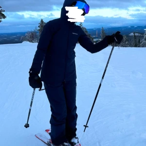 Mörkblått skidställ från Peak Performance - Säljer en mörkblå skidjacka + matchande skitbyxor från Peak Performance, supersnygga! Använt en säsong men säljer då de blivit för litet. Finns en ficka på armen för liftkort🤩säljer båda tillsammans för 4000kr! Kom privat vid frågor! priset går att diskuteras 