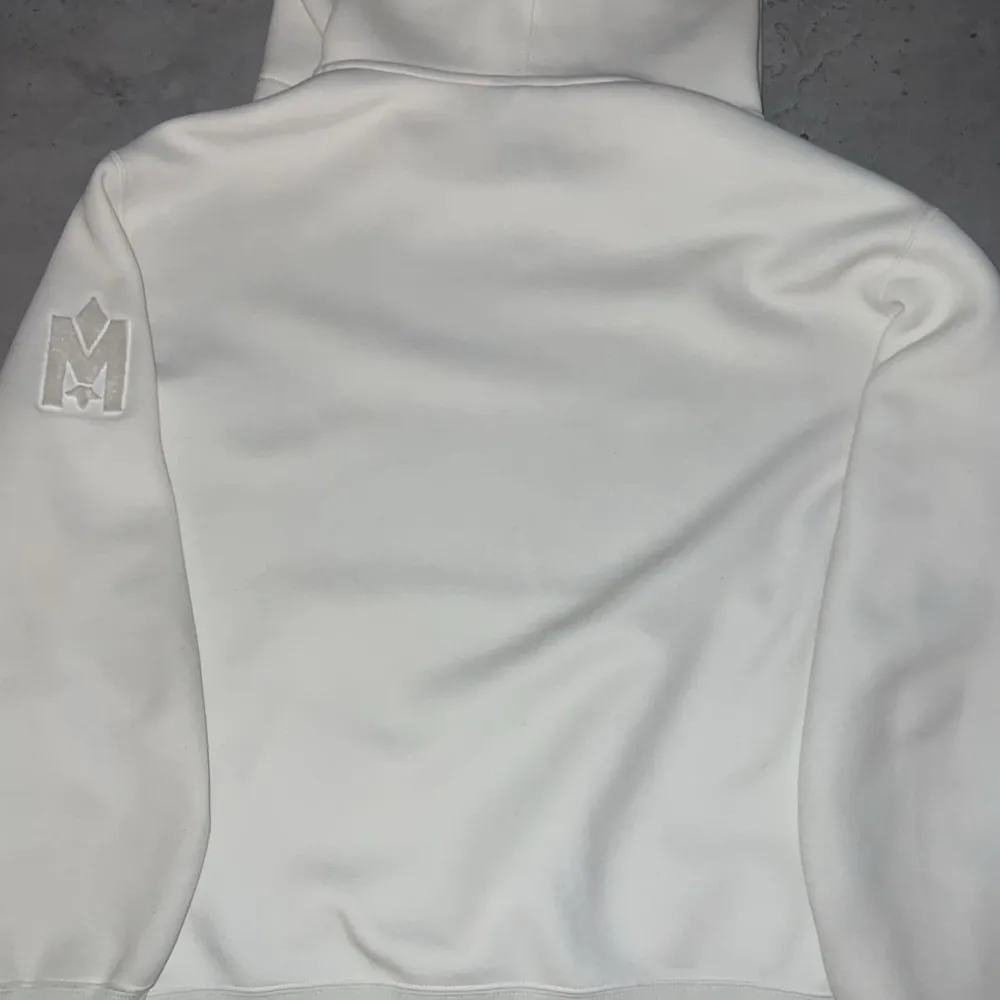 Säljer en stilren vit hoodie från Mackage med en broderad logga på ärmen. Den har en klassisk känguruficka och justerbar huva med snören. Perfekt för en avslappnad look. Pris går att diskutera ✅. Neuletakit & Villapaidat.