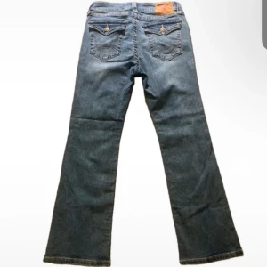 Blå jeans från True Religion - Snygga blå jeans från True Religion med bootcut-stil. Helt oanvända eftersom de inte passade. Midjemått: 36cm W26/W27