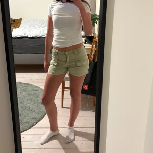 Gröna shorts med fickor - Snygga gröna shorts med praktiska fickor och knappdetaljer. Perfekta för en avslappnad stil. De är lågmidjade och har en normal passning.