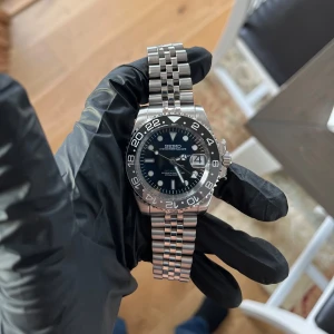 Seiko Gmt mod - Nu är detta Seiko Gmt modet färdigbyggt, klockan använder Seikos automatiska NH35A driv-verk. Klockan har en GMT funktion som kan visa två olika tidszoner samtidigt. Klockan har safir glas vilket inte repas. Det finns genomskinligt lock så att man kan se in i klockan. Diametern är 40 mm. Klocklåda ingår. Frågor? DM!