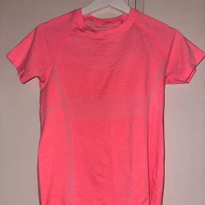 Rosa t-shirt från Topten Active - Säljer en snygg rosa t-shirt från Topten Active. Den är i bra skick och perfekt för träning eller vardagsbruk. T-shirten har en normal passform och är kortärmad, vilket gör den idealisk för sommarens varma dagar. Materialet känns mjukt och bekvämt mot huden.