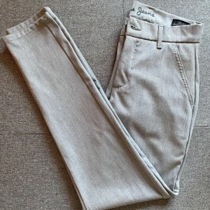 Grå byxor från Sam's Jeans - Säljer ett par stilrena grå byxor från Sam's Jeans. De har en klassisk design med normal passform och är perfekta för både vardag och mer formella tillfällen. 