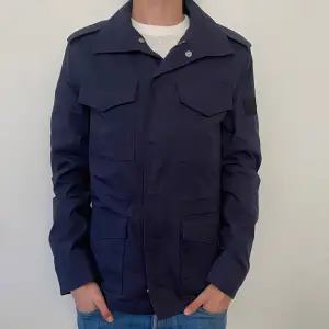 Riktigt snygg Field jacket från Pierre Cardin. Storlek på jackan är S, jackan är i nyskick 10/10 finns inga defekter. Nypris: ca 3000 mitt pris:899. Hör av er vid frågor och funderingar!