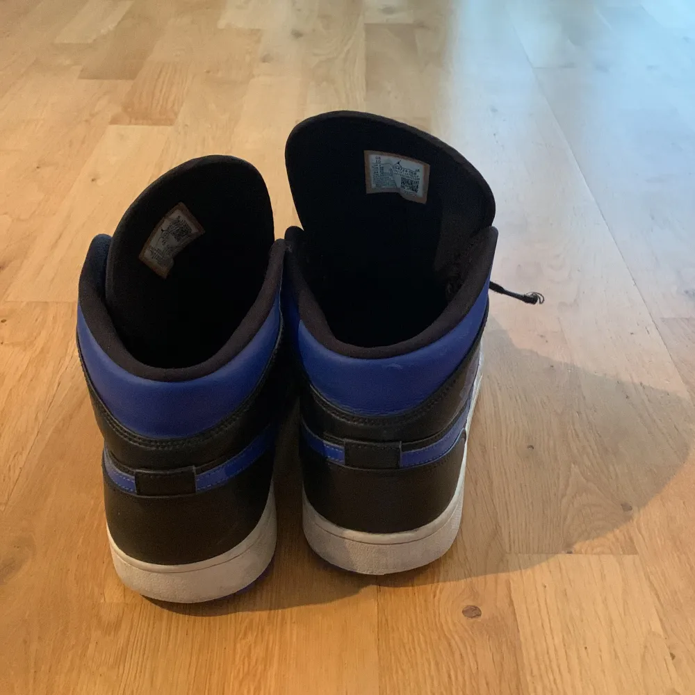 Säljer ett par snygga Nike Air Jordans i svart och blått. Skorna har en klassisk hög modell med snörning och den ikoniska Jumpman-loggan på plösen. Perfekta för både vardag och fest, och de ger en riktigt cool streetwear-look. De är i bra skick och redo för nya äventyr!. Skor.