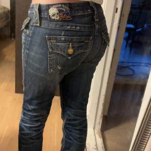 Säljer ett par snygga blå jeans med jättefina detaljer på bakfickorna. De är en blandning av straight och bootcut och är jätte lågmidjade🩷 köpte för 1000kr på Vinted. Innerbenslängd 82cm💕