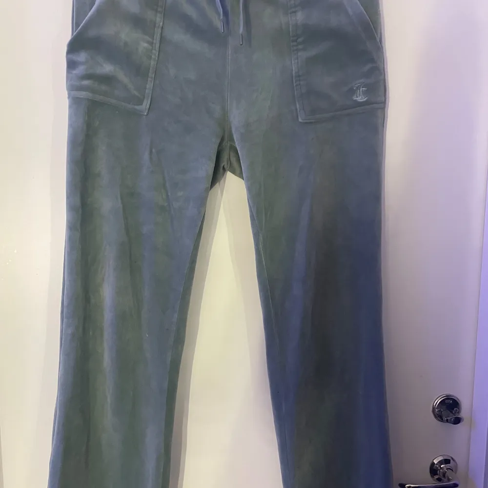 Säljer ett par gröna mjukisbyxor ifrån juicy couture i skönt material. Byxorna har en loose passform och är högmidjade med snörning i midjan. metall sakerna på snöret i midjan saknas men utöver det är dom i perfekt skick och är jätte snygga och sköna sitter bra i längden på mig som är runt 160 165 lång . Farkut & Housut.