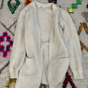 Vit lång cardigan - Fin vit cardigan från hm, har nästan aldrig användt och skulle säga att den är S💓