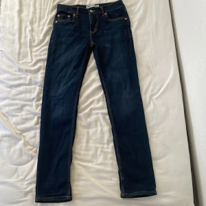 Levi's 512 Slim Taper Jeans - Säljer ett par snygga Levi's 512 Slim Taper jeans i mörkblå färg. De är i bra skick och har en slim passform med avsmalnande ben. Perfekta för både vardag och fest! 🕺
