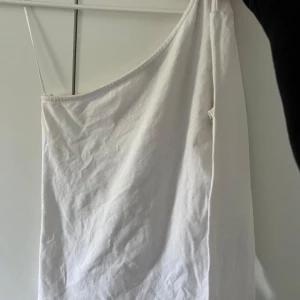 Vit oneshoulder klänning - Säljer en snygg vit oneshoulder topp. aldrig använd