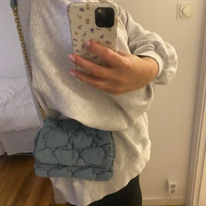 Väska H&M - Liten axelremsväska i jeanstyg. Endast använd fåtal gånger.