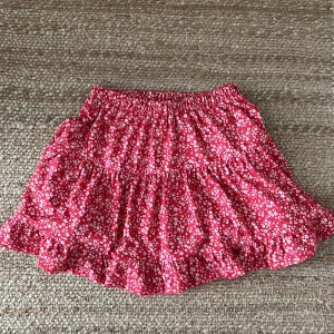 Röd blommig kjol från NLY Trend - Säljer en helt ny och superfin röd blommig kjol från NLY Trend. Kjolen är i storlek S/Xs och har ett elastiskt midjeband för en bekväm passform. Perfekt för sommaren!🌸. Kostar 350kr ny men säljer den för 99kr då jag gärna vill få den såld 