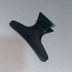 Svart hårklämma - Säljer en svart hårklämma i plast. Perfekt för att hålla håret på plats under dagen. Klämman har en enkel och stilren design med starkt grepp.
