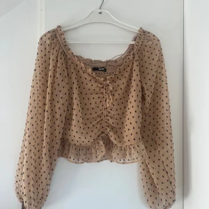 Beige prickig topp från Bik Bok - En lätt blus ifrån Bik Bok i storlek s, med justerbara knyten framtill.