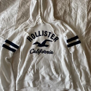 Hollister hoodie - Vit hoodie med svartblå detaljer. Väldigt mjuk på insidan och utan defekter. Använd några gånger men inte så att det är synligt. Storlek XS