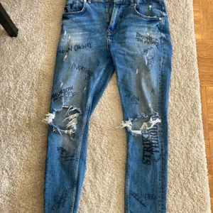 Mörkblåa zara Jens  - Zara Jens med text tryck och hål vid knäna lite tajt storlek 38 knappt använda låg midja frakt ingår inte 