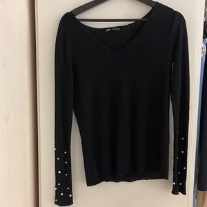 Tröja i strl S - Svart tröja med pärlor på ärmarna från Zara. Köpt för 2 år sedan och använd ett par gånger. Men i bra skick och form. Strl är S/M Köparen står för frakten.🤍