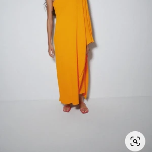 Klänning från Zara - Klänning med ena axeln bar.  Clementinfärgad stl S/M Oanvänd med tags kvar Mjuk och stretchig