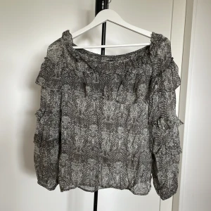 Grå top med volanger! - Går at tja på båda axlarna, bara på en eller helt off-shoulder.🌟