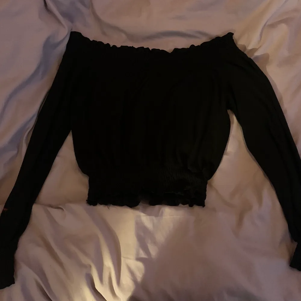 stretchiga svart off shoulder tröja från Gina. Ribbad vid midjan och slutet av ärmarna. Tröjor & Koftor.