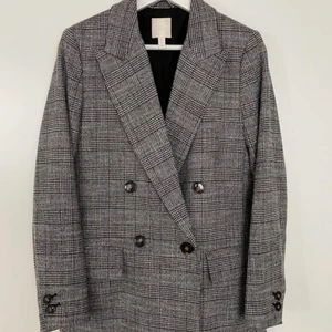 Grå rutig dubbelknäppt blazer / kavaj från H&M trend  - Grå rutig dubbelknäppt kavaj från H&m trend. Nyskick! Storlek 38 men pssar 34 och 36 då den sitter som snyggast lite löst. Perfekt kavaj nu mot förhösten till jeans och sneakers! 