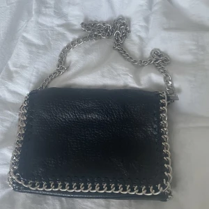 Tiamo väska - Super fin Tiamo väska❣️Väskan rymmer ganska mycket. Finns två fack, ett på insidan och ett utanpå i bak. Färgen har försvunnit lite på vissa ställen på kedjan, men inget man tänker på.