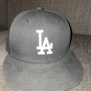 LA keps - Säljer denna svarta LA keps helt o använd och köpte den från hatstore för 500kr. Den är rätt liten för storleken skulle säga att den passar ett 55cm o upp