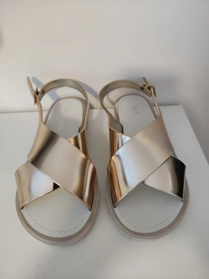 Guldfärgade sandaler. - Guldfärgade sandaler från Asos. Använda en gång.