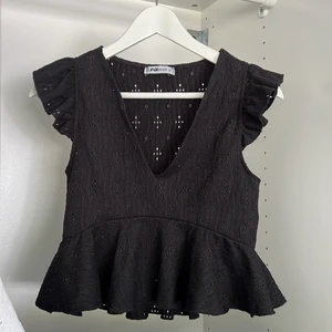 Svart volangtopp - Säljer denna superfina volangtoppen i svart. Använd ett fåtal gånger, men i mycket bra skick!!✨✨nypris 299kr, från förra året och säljs inte längre. 