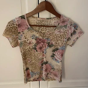 Blommig topp. - Blommig topp som sitter rätt tajt. Köpt i second hand affär. Använd ett par gånger och är i bra skick. 