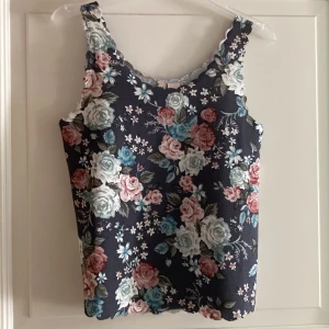 Blommigt linne - Ett blommigt blågrått linne från H&M Divided. Det är stretchigt material. Storlek S. Använt några gånger, men ser nytt ut. 40kr. 