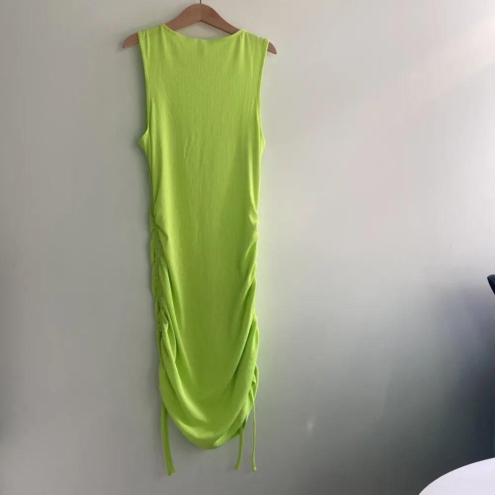 Neon grön klänning med scrunch på sidorna. Köparen står för frakten . Klänningar.