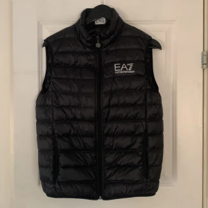 EA7 väst - Emporio Armani väst i storlek S. Den är i väldigt gott skick och aldrig använd. Köpt på JDsports. Orginalpris 1200 kr. OBS står ej för frakten.