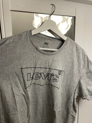 2 st t-shirts från Levi’s - Säljer nu två stycken T-shirts från Levis i bra skick! En mörkgrå med streckat märke och en i olivgrön med svart märke. Båda två i storlek Xl i bra skick med inga skador eller slitningar. Säljes båda två i paket för 100 kr