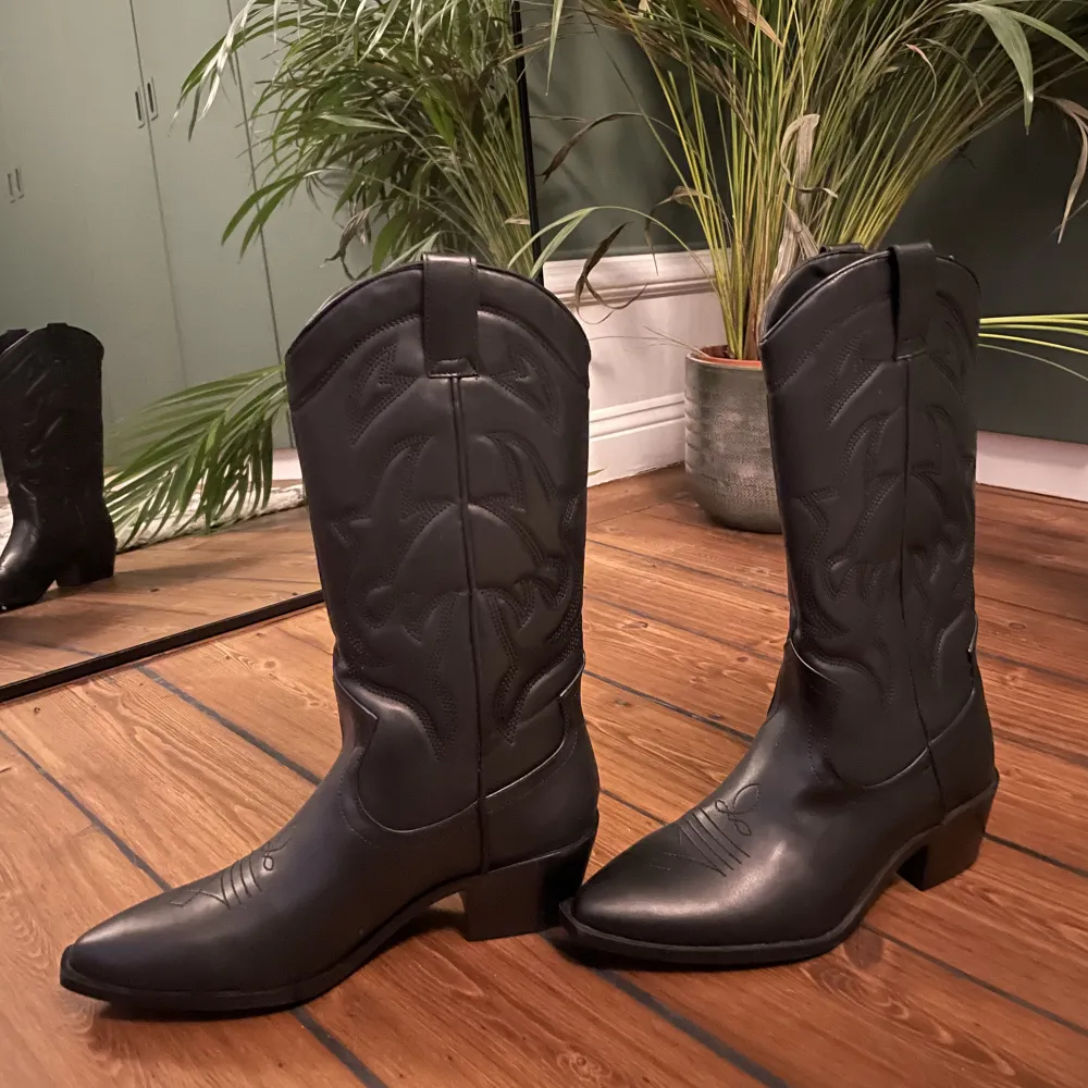 Säljer ett par helt oanvända svarta cowboyboots från Stradivarius. Lappen sitter kvar! Storleken på lappen är 39 men skulle absolut säga att det är en 38, då jag säljer eftersom dem är för små!. Skor.