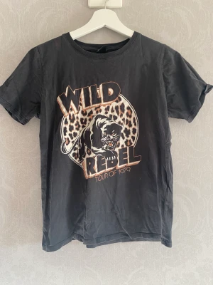 T-shirt med tryck  - T-shirt med tryck  Storlek: Small  Finns två små fläckar från blekning som inte går bort men knappt syns. Se bild! 