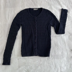 Stickad cardigan - Marinblå stickad cardigan/kofta med knappar. Väldigt stilren och class. Aldrig använd, perfekt skick!!