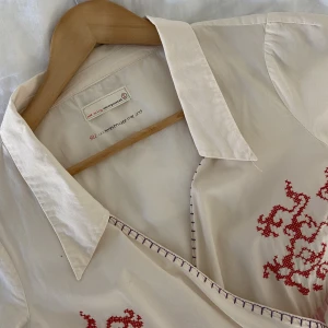 Odd Molly - vit & rosa klänning - Vit & rosa klänning från Odd Molly i storlek 2 (S). Broderier och detaljer i rött, gult, lila och ceriserosa. Använd få gånger, inga tecken på användning!