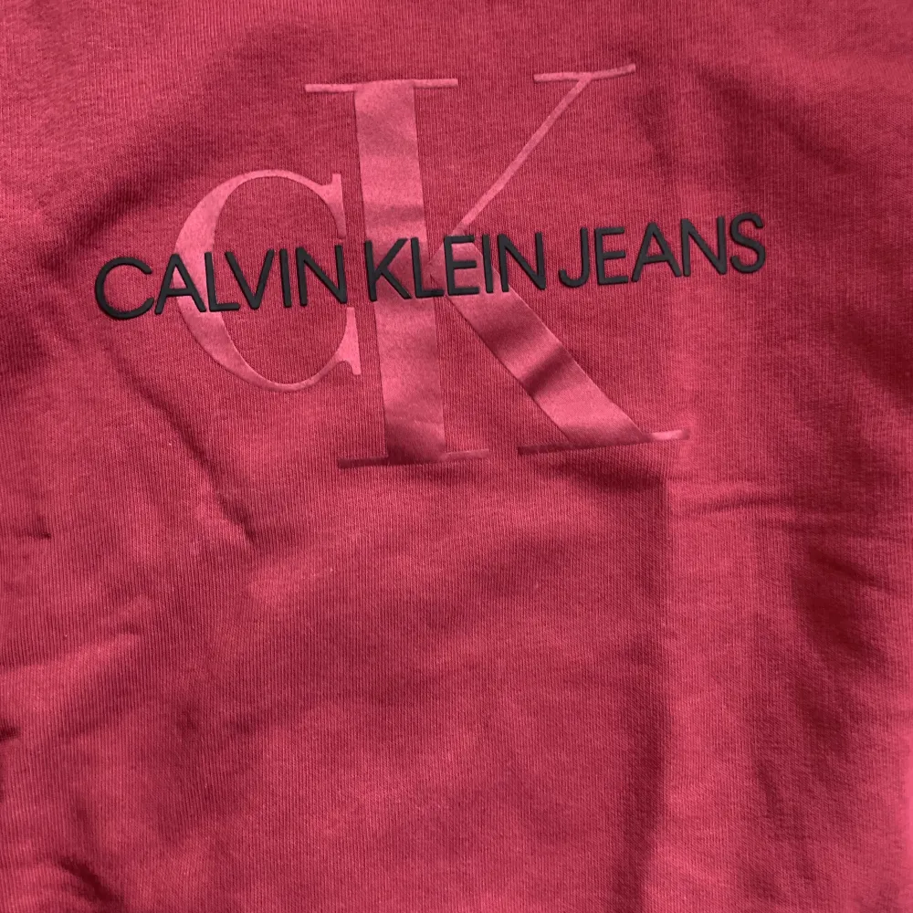 Vinröd långärmad tröjan med märket Calvin Klein köpt från kidsbrandstore! Nästan aldrig använd. Storlek xs och såklart kommer den strykas och tvättas en extra gång innan du köper den!. Hoodies.