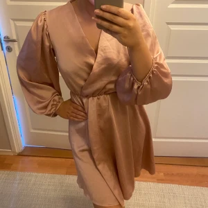 Rosa klänning - Säljer en rosa ”satinklänning” som tyvärr aldrig kommit till användning! Den är onesize men skulle säga att den passar S/M/L beroende på hur den ska sitta. Den har superfina stora puffiga armar! Skriv privat för fler bilder eller frågor!💞