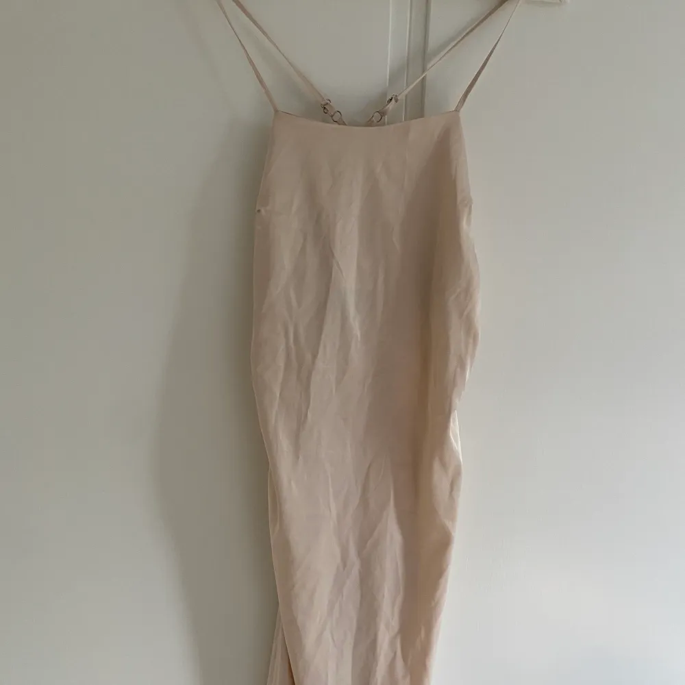 Oanvänd, fin och sömmad lång festklänning med slits på sidan. Den formar kroppen väldigt snyggt . Klänningar.
