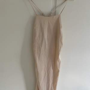 Oanvänd, fin och sömmad lång festklänning med slits på sidan. Den formar kroppen väldigt snyggt 