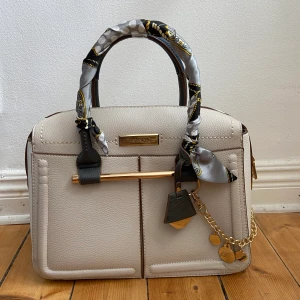 Väska River Island - Vit väska från River Island med scarf- och gulddetaljer.