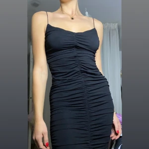 Svart klänning 🖤 - Lång svart klänning från ASOS. Använd vid ett tillfälle - nyskick!💥 Klänningen är vackert ”ryschad” på både fram & baksida (se bilder).  Klänningen passar perfekt till dejt / fest🪩